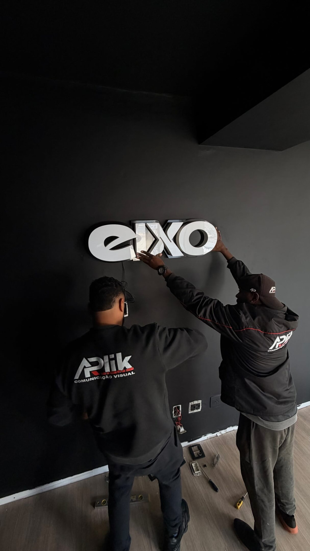 Equipe da Aplik Signs instalando letreiro luminoso EXXO